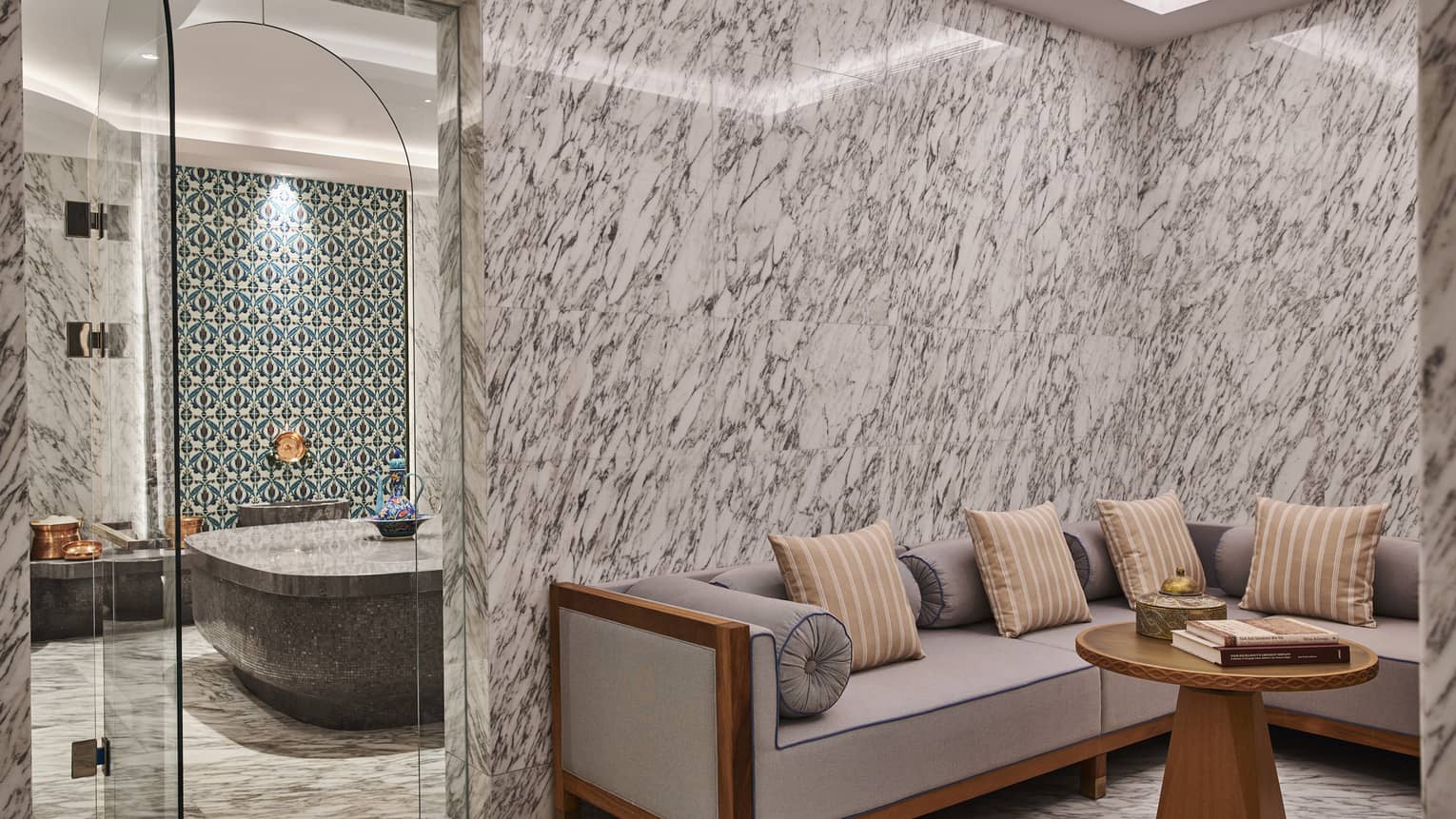 Kuma Spa seating area with sofa and table next to door leading to bathing room