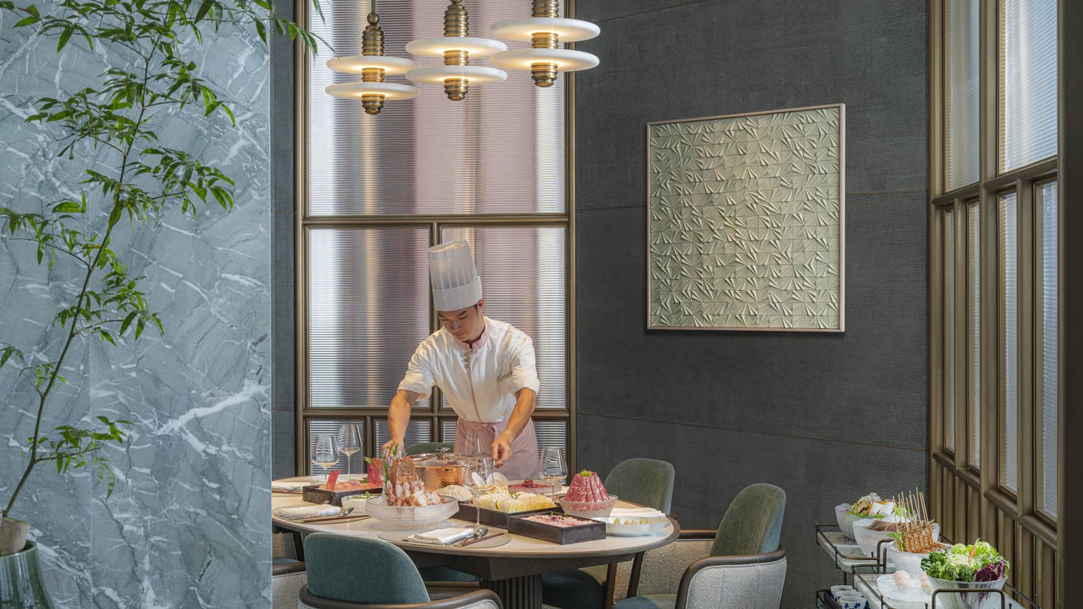 Chef places food on a dining table at restaurant Charm at Four Seasons Hotel Hangzhou at Hangzhou Centre
