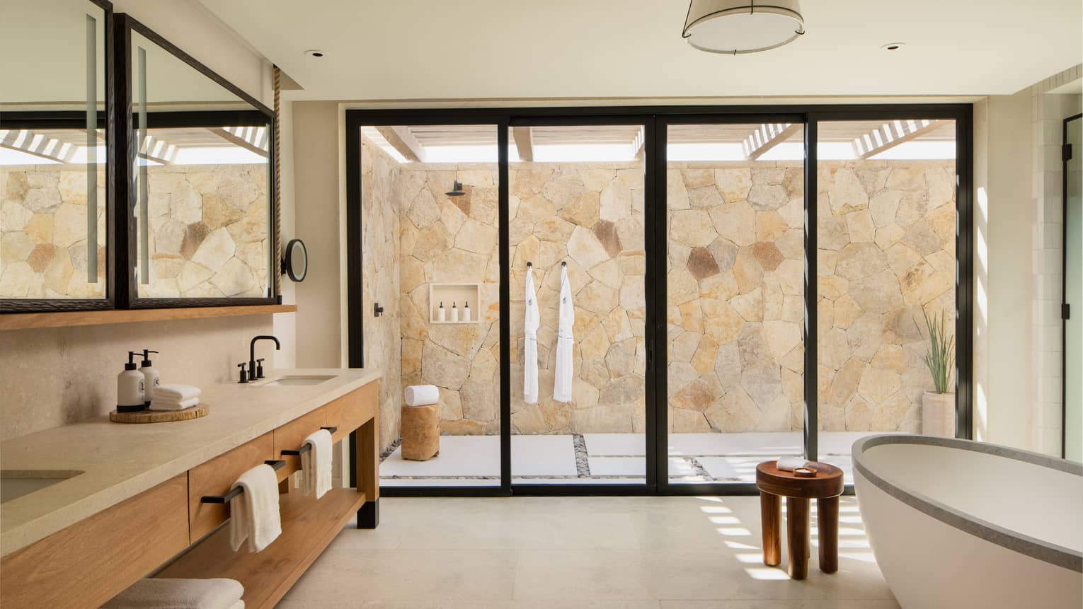 Large, chic bathroom with standalone tub, long double vanity and outdoor shower at Four Seasons Resort Cabo San Lucas at Cabo Del Sol