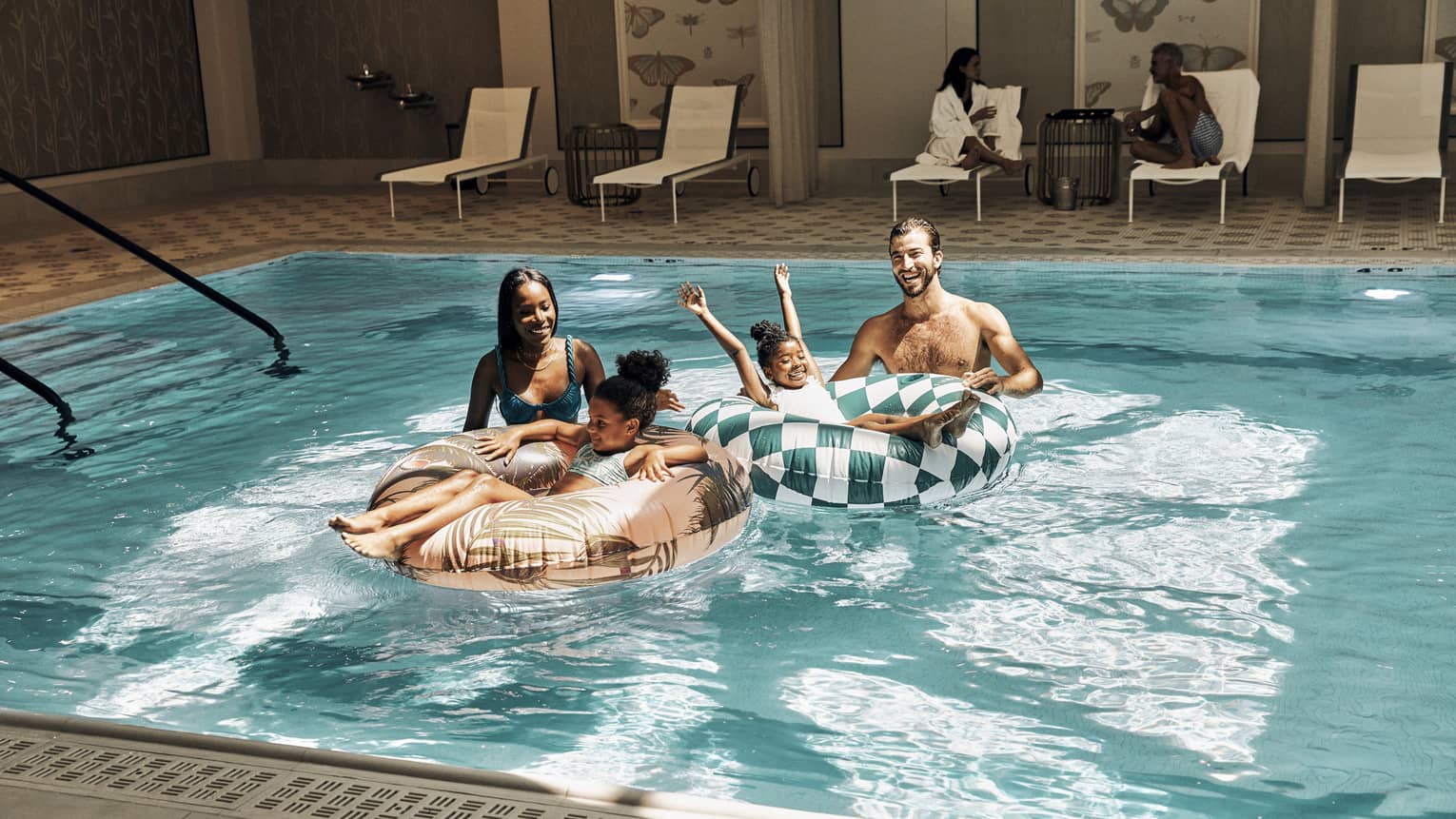 A family in a pool with round tubes.