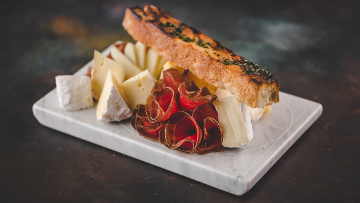 A fish filet served with a variety of cheeses.