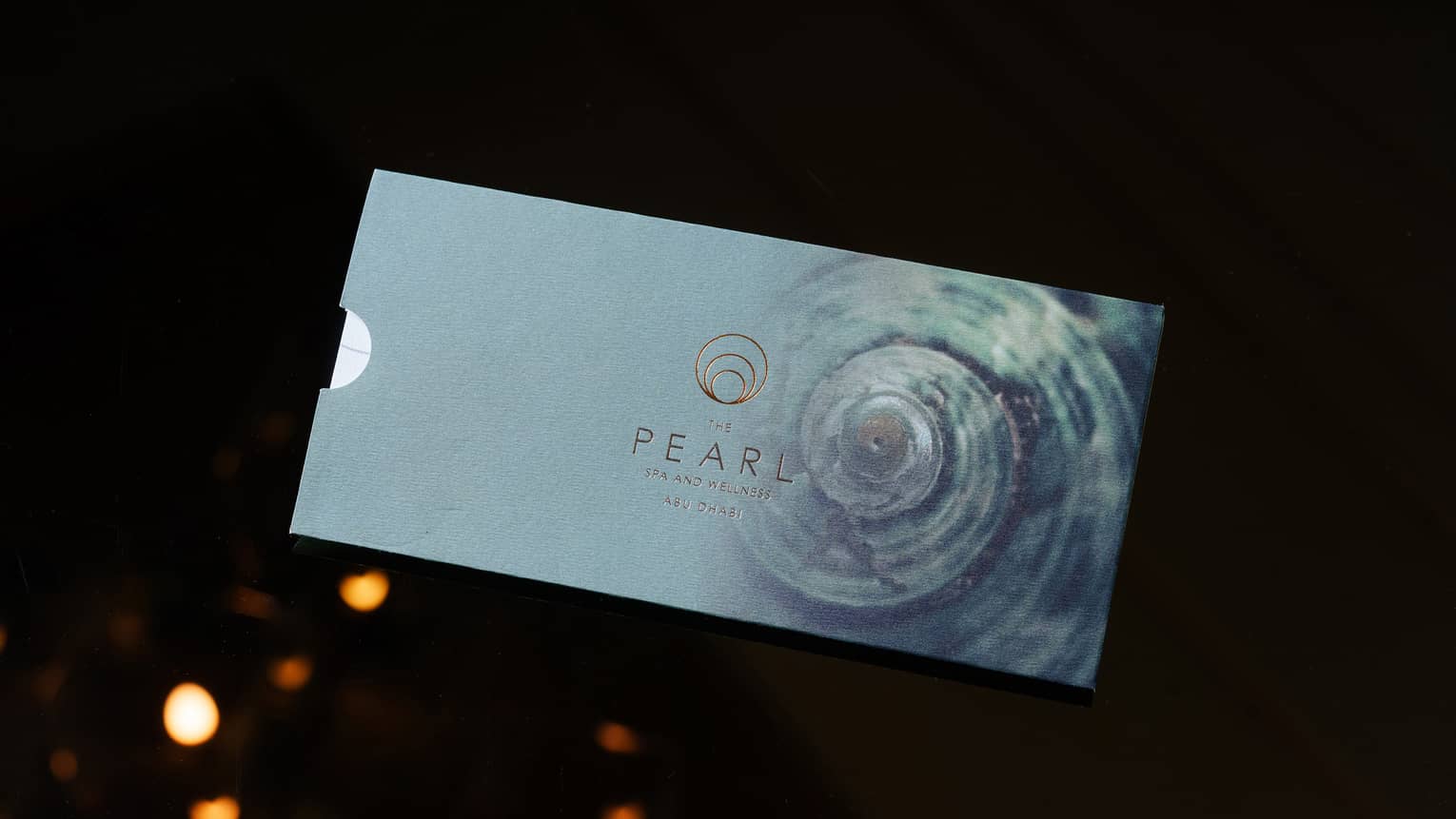 Light-blue metallic gift card for The Pearl Spa set on a black backdrop