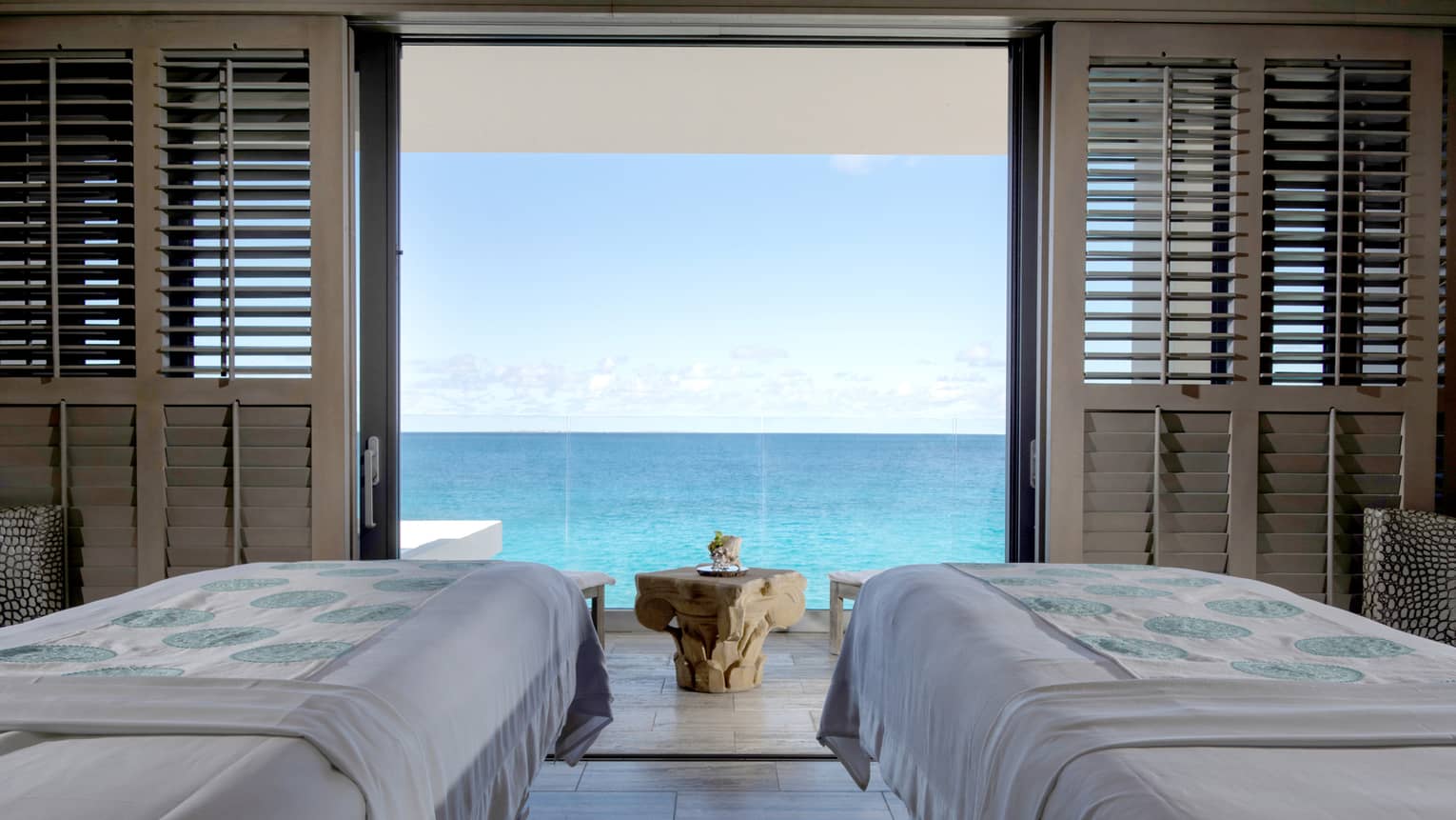 Couples massage beds in private spa cabana looking out at the ocean