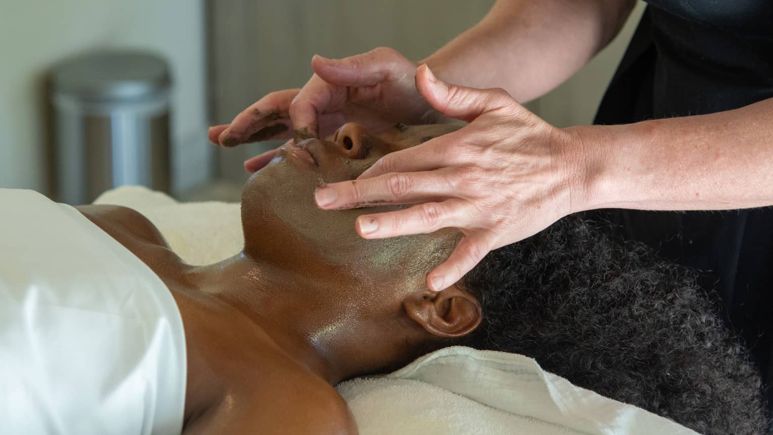 A woman receiving a facial massage.