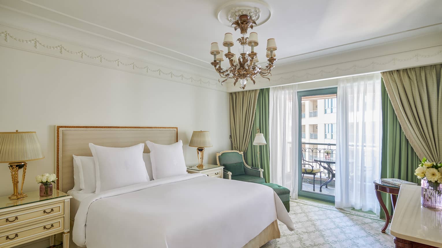 Four Seasons Suite bedroom with king bed, corner chaise longue, side table, glass door to veranda