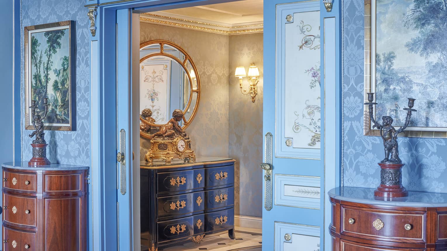 Presidential Suite entryway with cherry sideboards on either side of doorway, blue patterned wallpaper and wall art