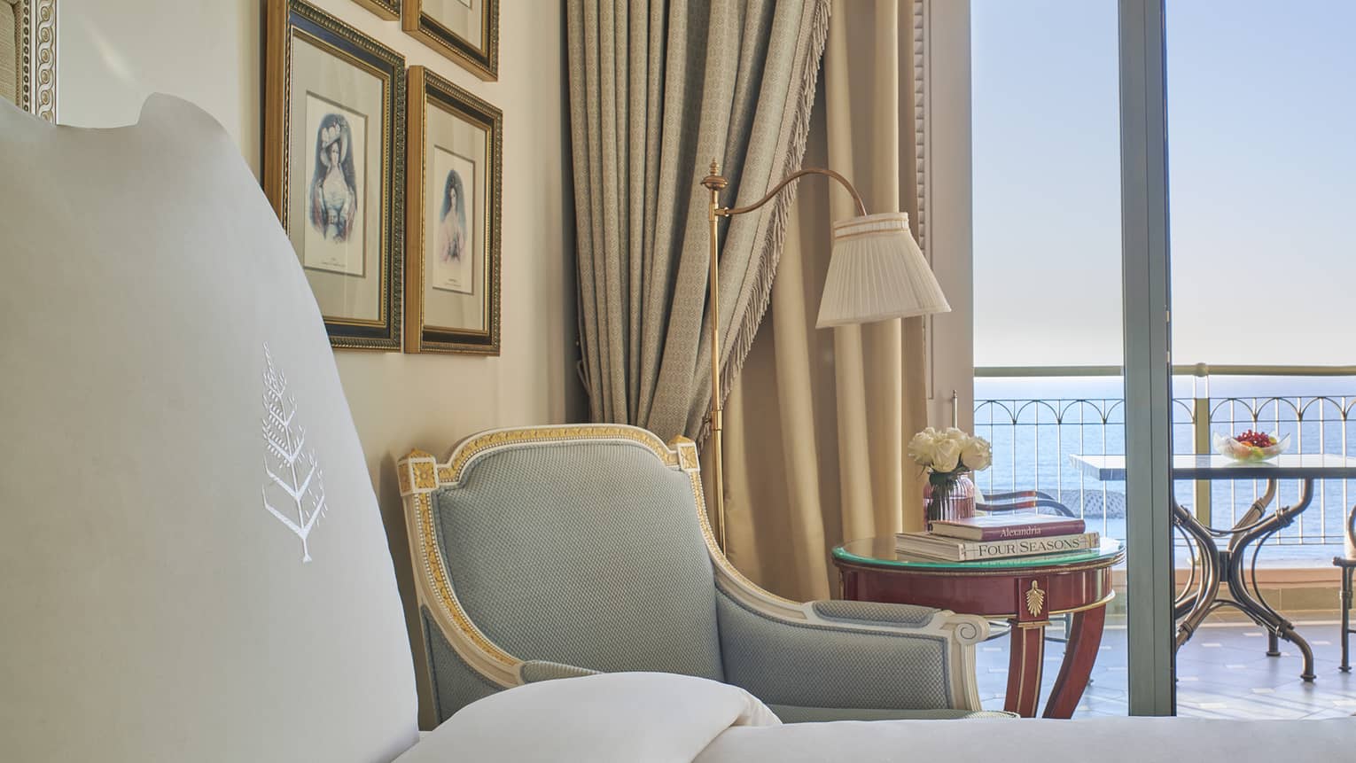 Sea View Room close-up of bed, armchair, side table, veranda with ocean views