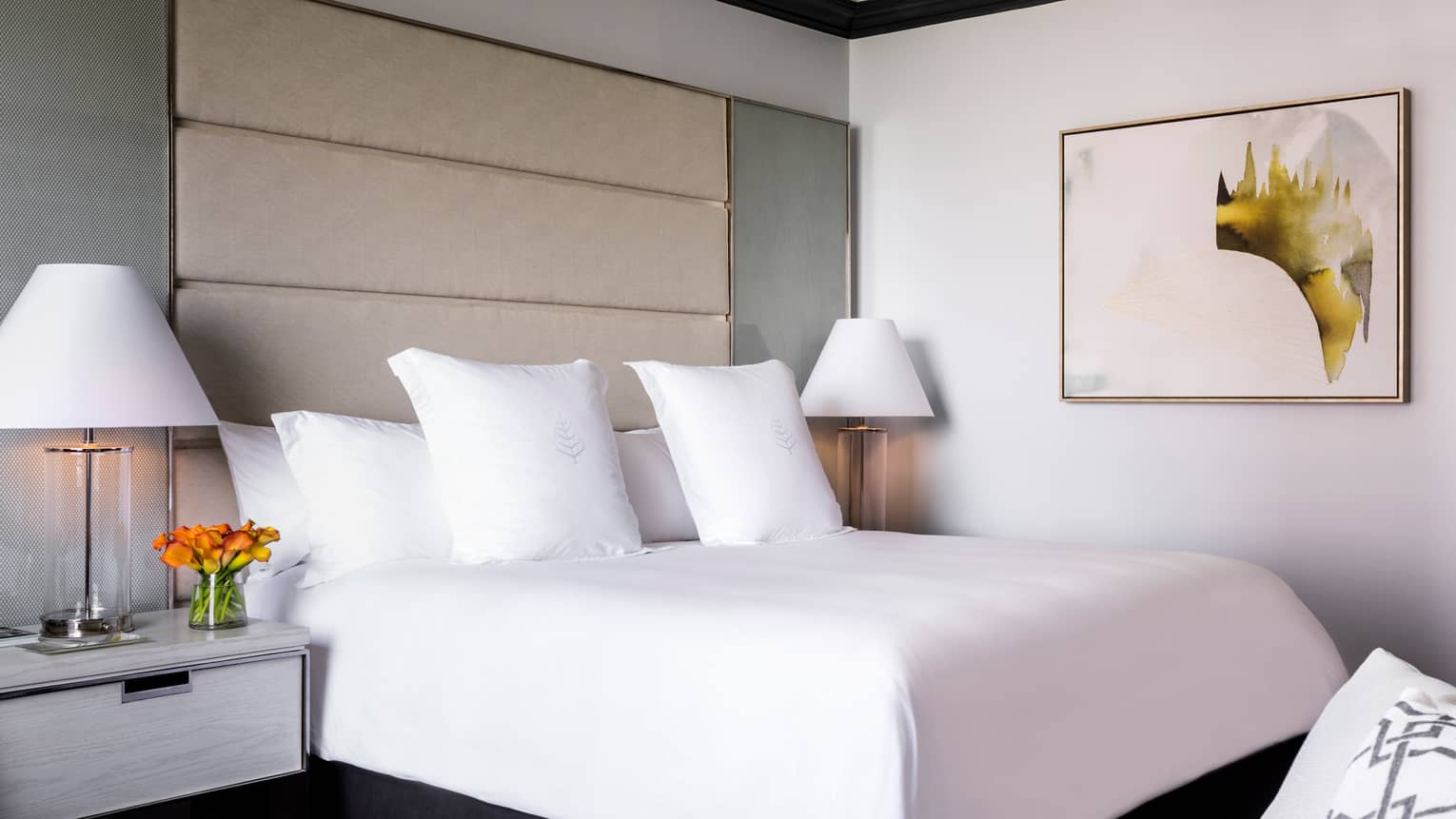 Midtown Premier Room white bed, linens in front of tall padded headboard, framed abstract art on wall