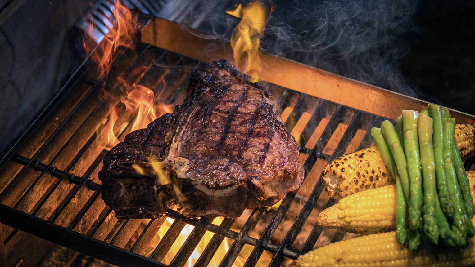A juicy steak sizzles on the grill alongside fresh corn and vibrant asparagus, creating a delicious outdoor cooking scene.,A juicy steak sizzles on the grill alongside fresh corn and vibrant asparagus, creating a delicious outdoor cooking scene.