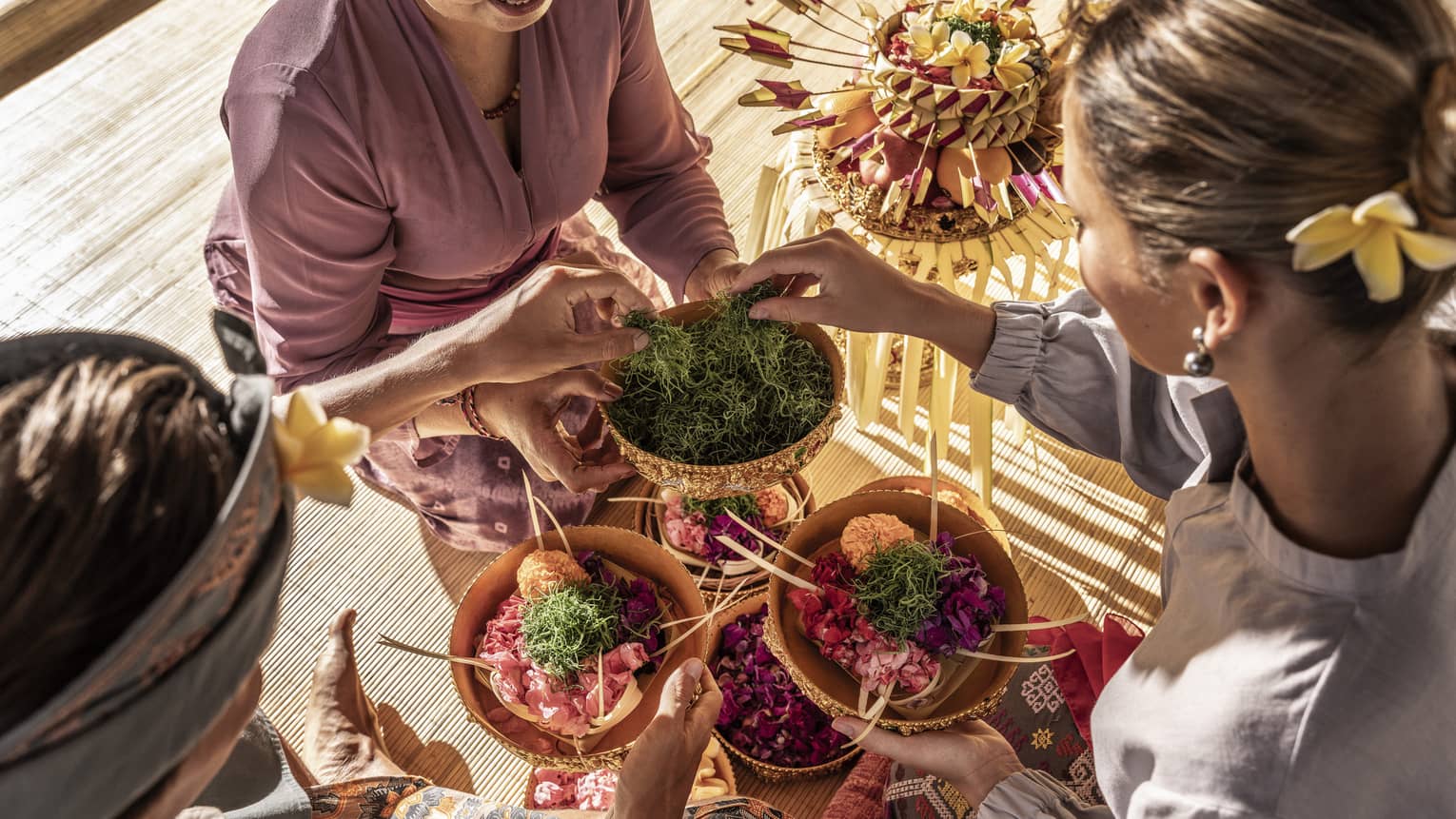 Two guests select green moss from bowl to top their own colourful creations