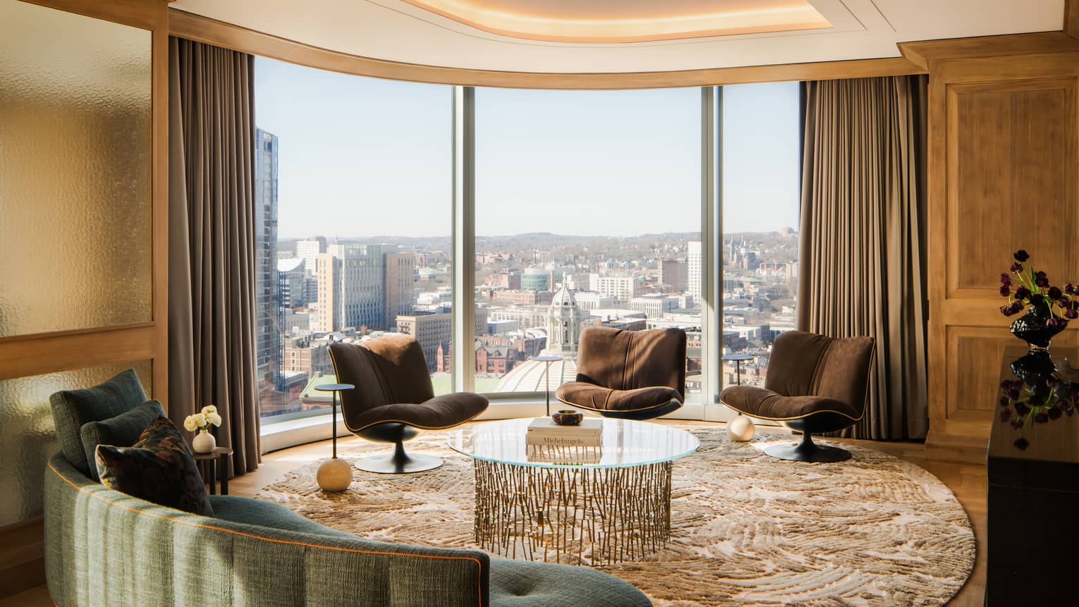 Contemporary living room with curved wall of windows looking out over a city