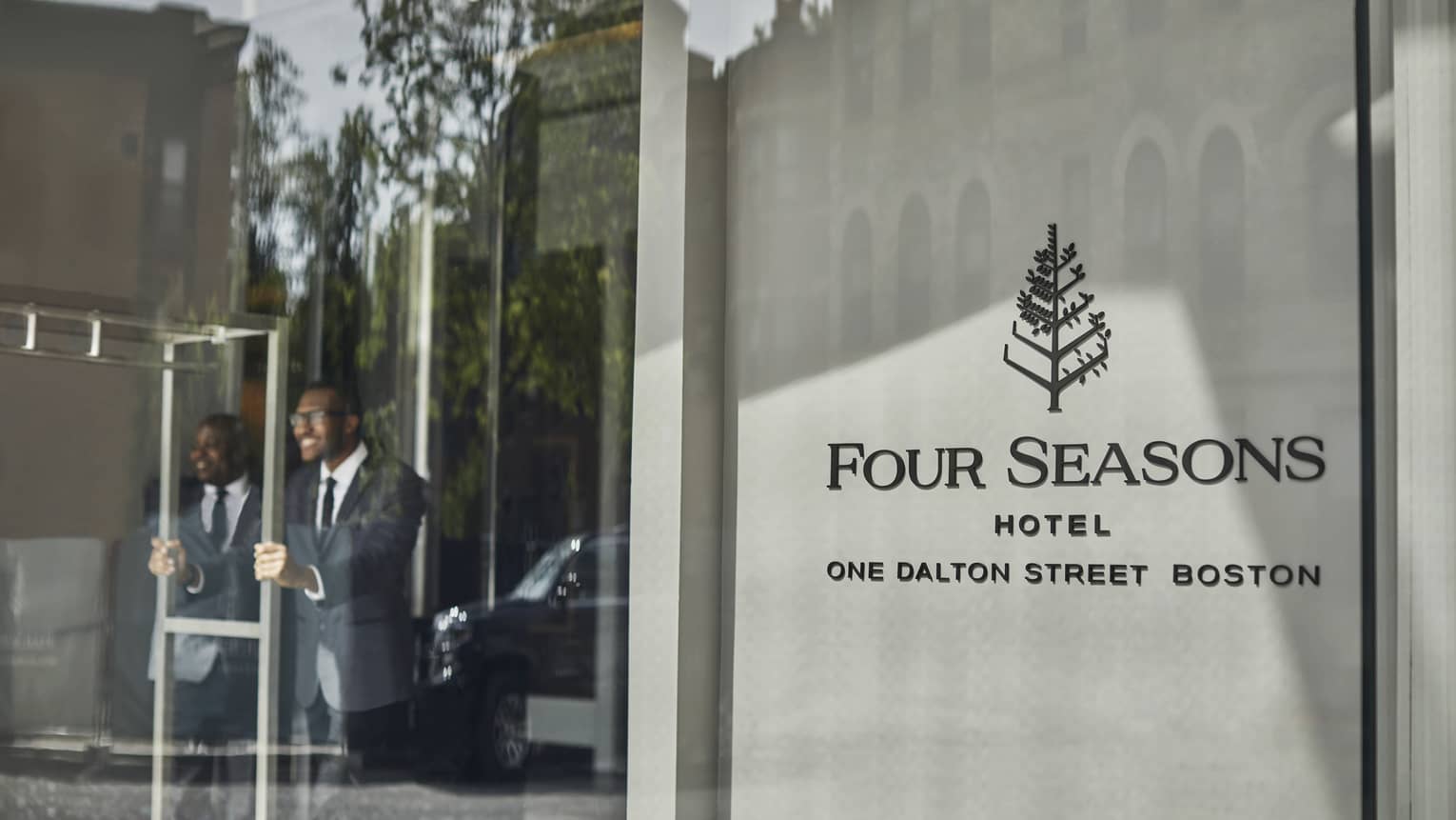 Four Seasons staff open the entrance door for guests 