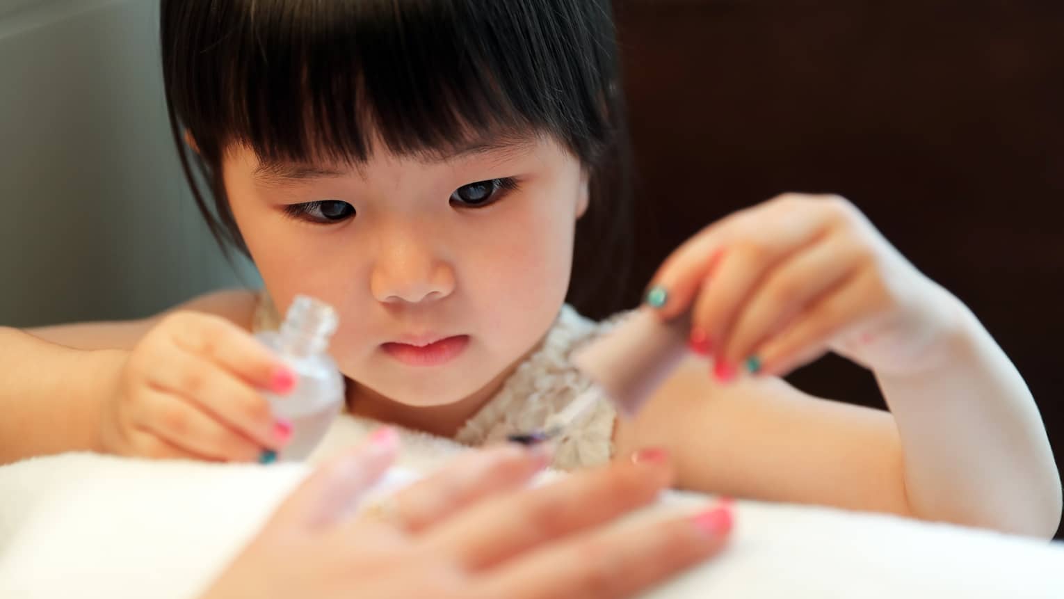 Young girl gives manicure to an adult out of frame