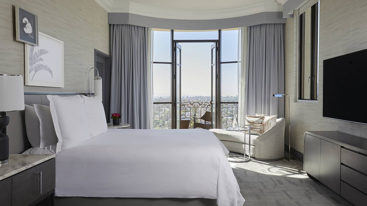 Bedroom with king bed and city-view balcony