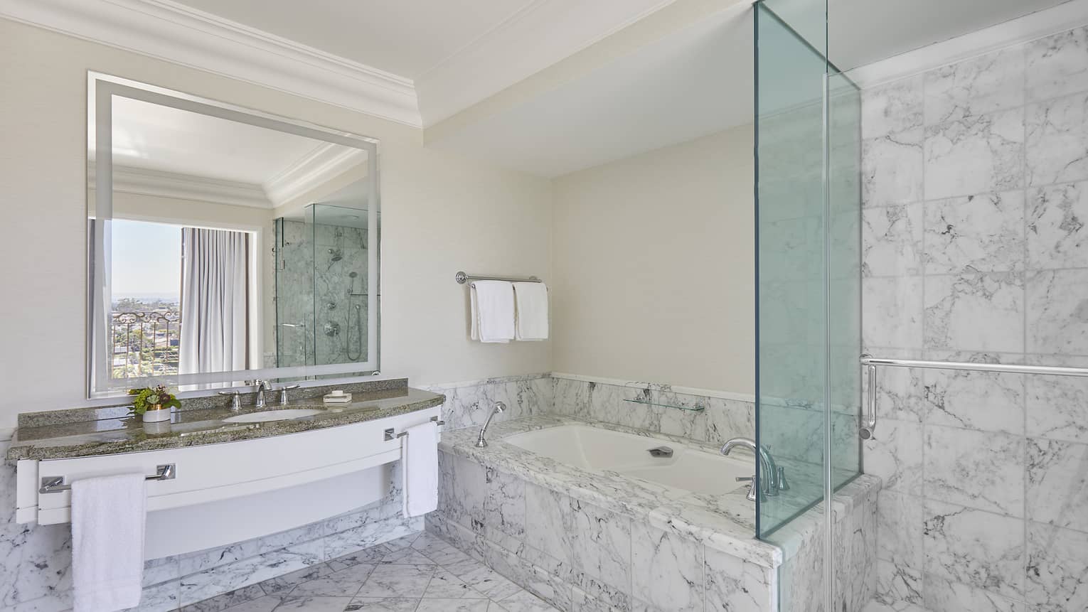 Marble bathroom with glass shower and separate tub