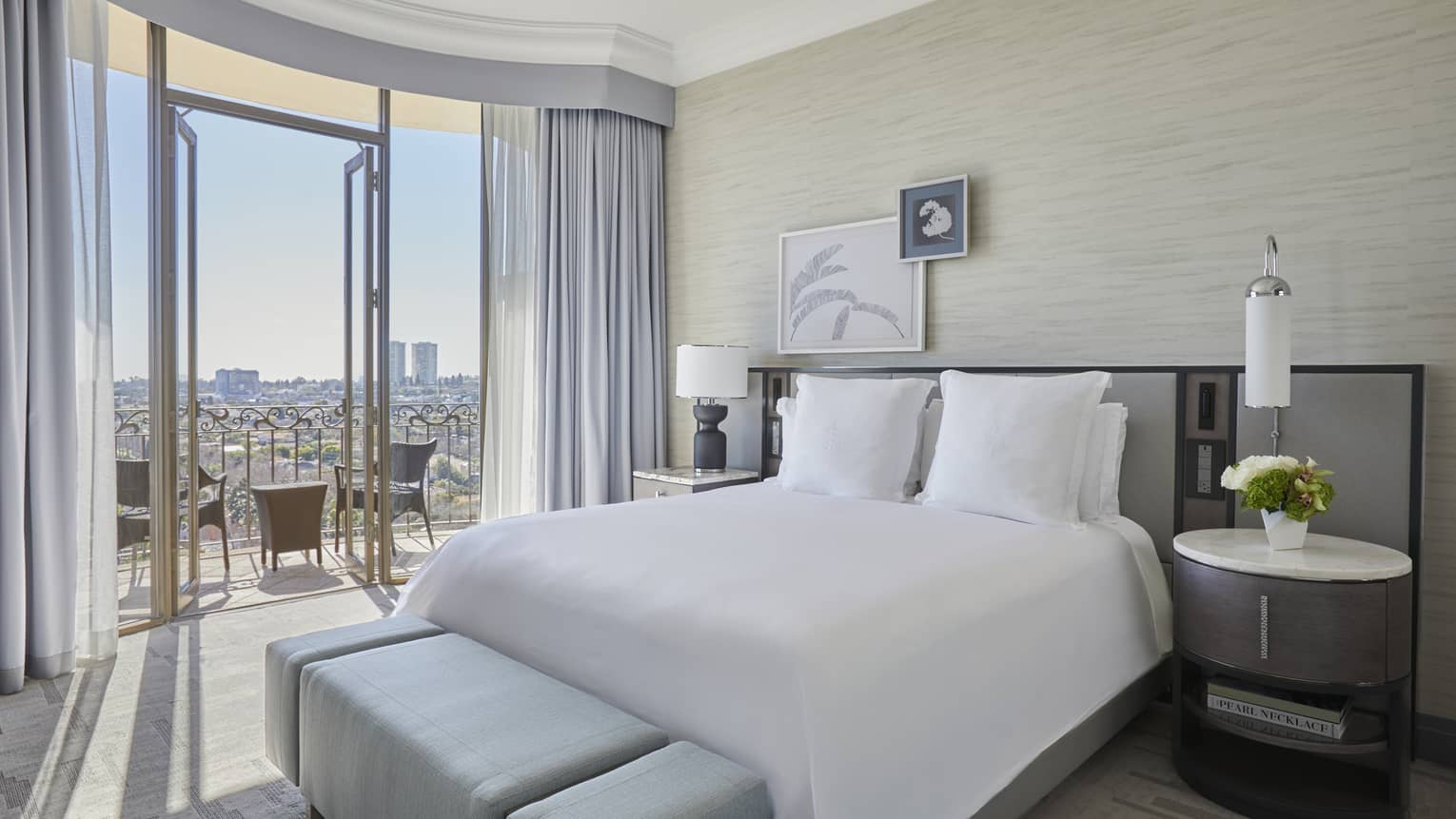 Hotel room with king bed and city-view balcony