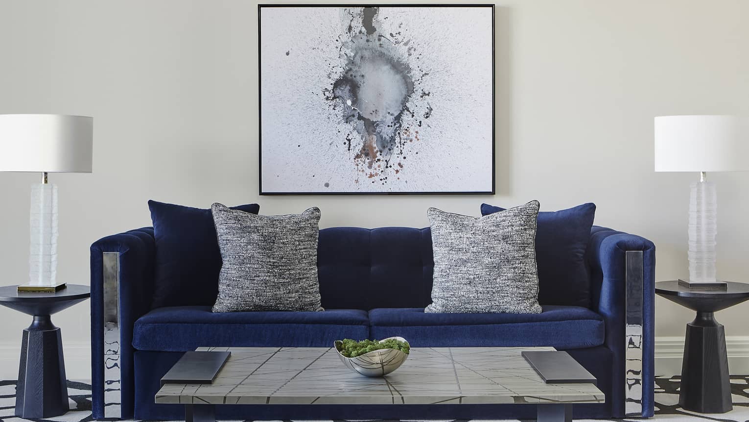 Dark blue sofa, coffee table and artwork on the wall