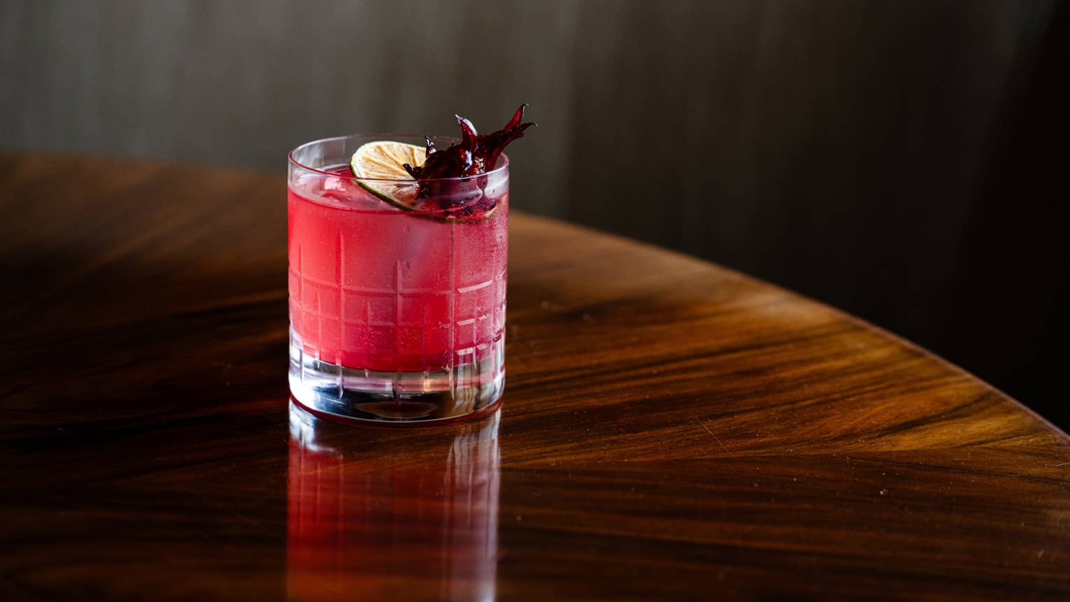 Pink drink with slice of lemon on top.