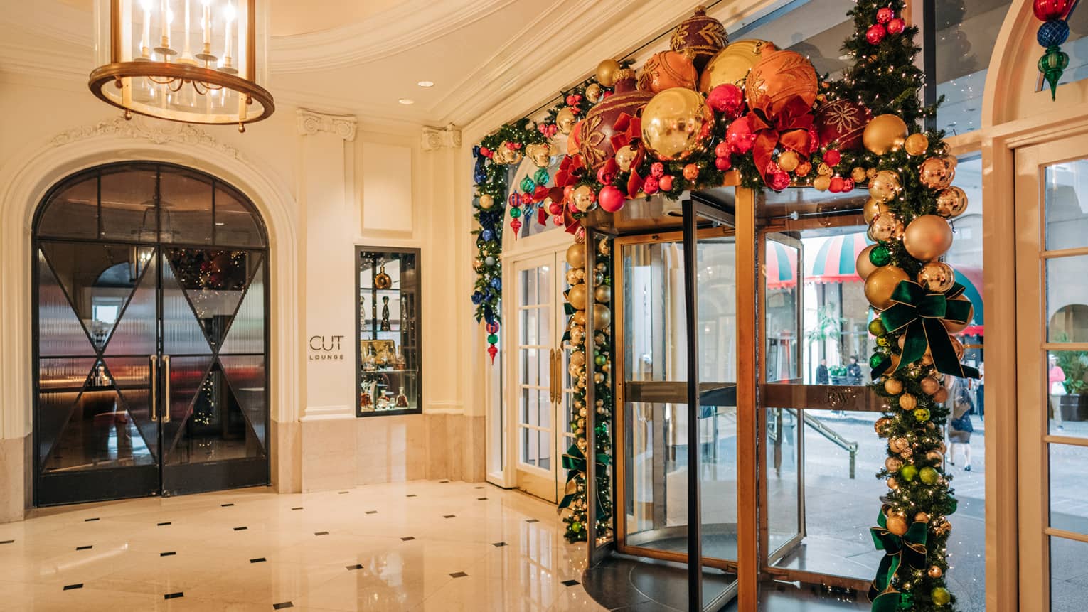 Hotel entrance rotating door decorated with holiday garland and ornaments