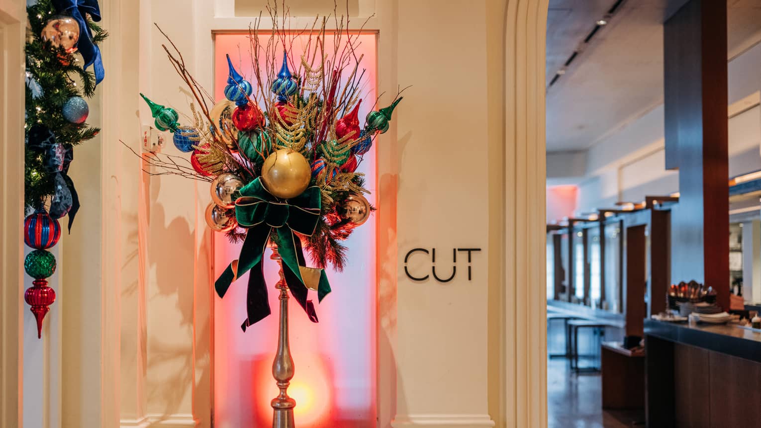 Festive floral arrangement with ornaments at entrance to luxury restaurant