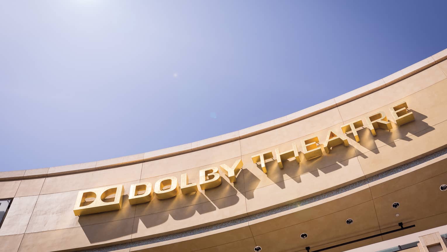 Curved Dolby Theatre sign against sunny blue sky