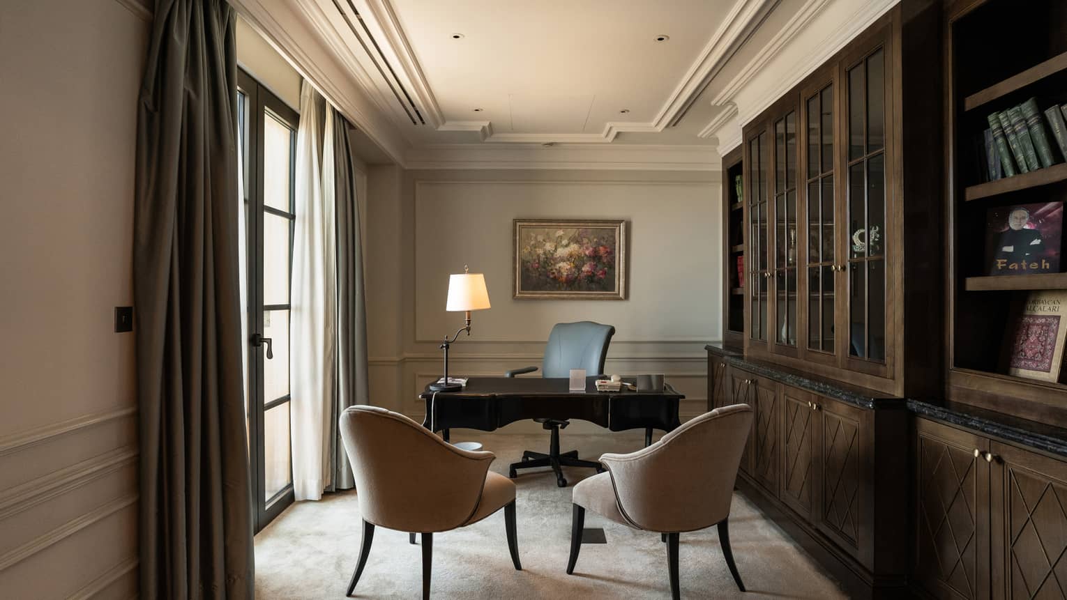 Study with desk and wall of dark-wood shelves