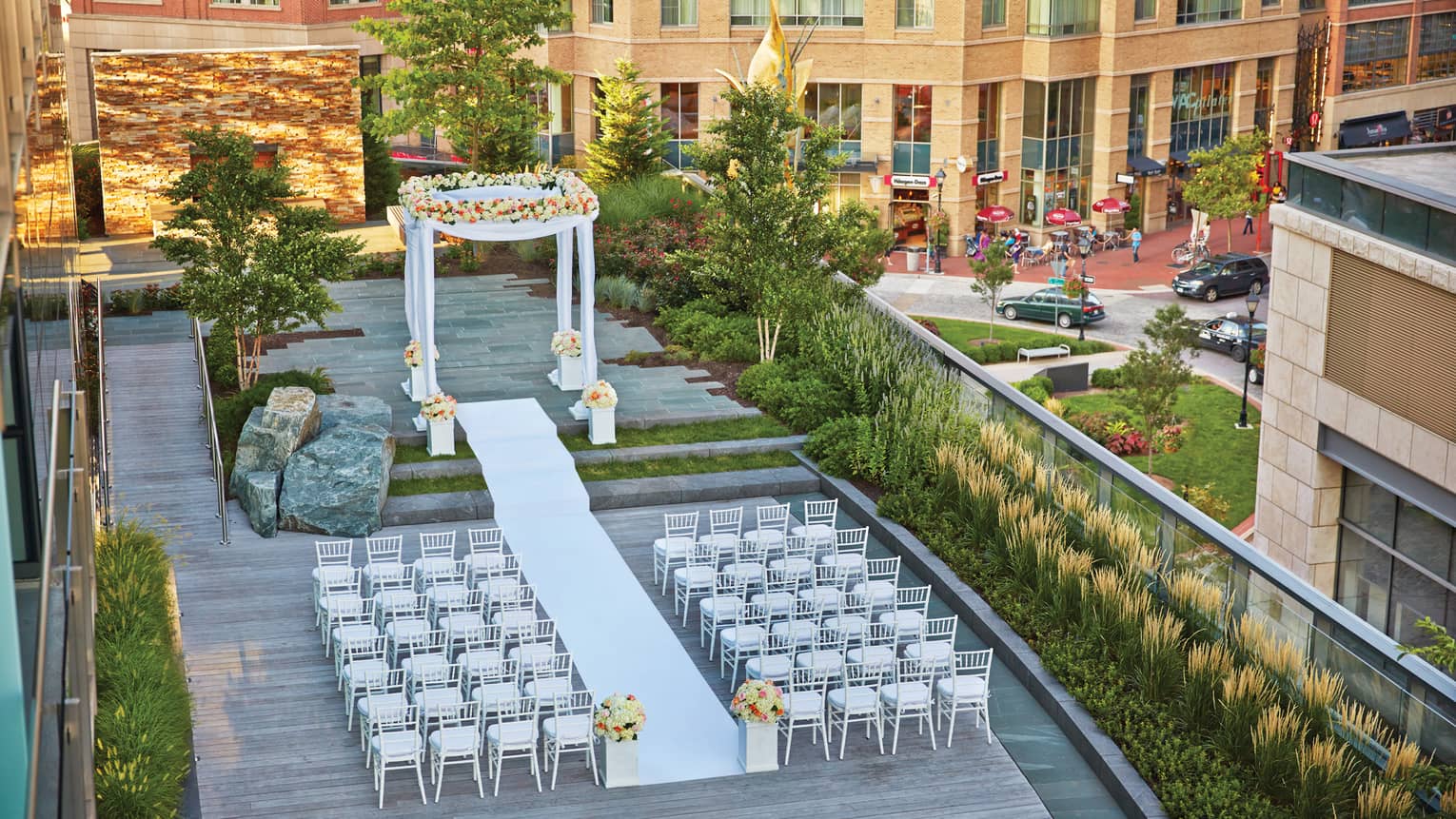 Aerial view of large outdoor patio wedding ceremony, altar in front of rows of white chairs