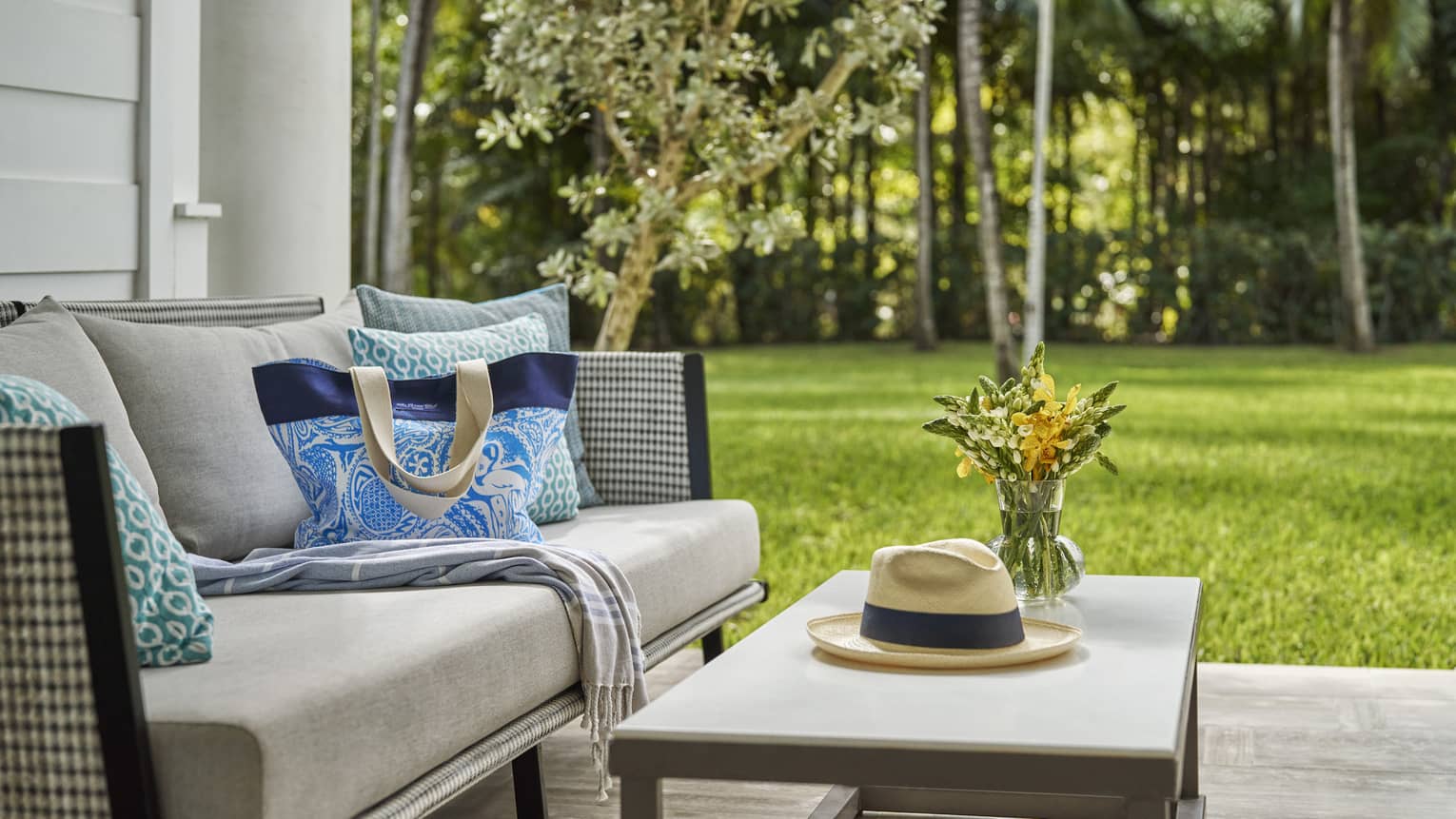 Terrace with two-seat sofa and coffee table, set against a lush green lawn