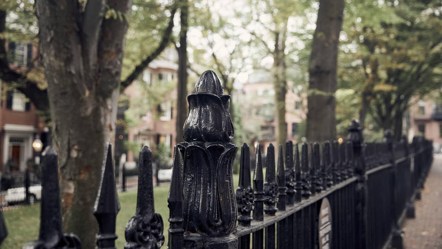 A close-up of a wrought iron fence in downtown Boston, lining a park