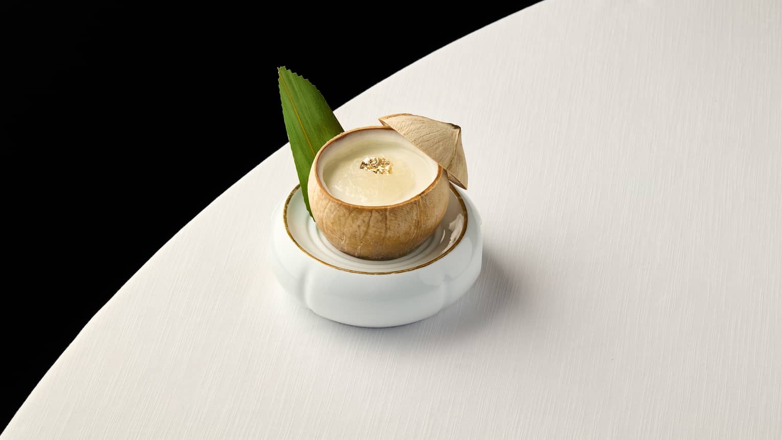 Pina Colada cocktail in a coconut on a white table