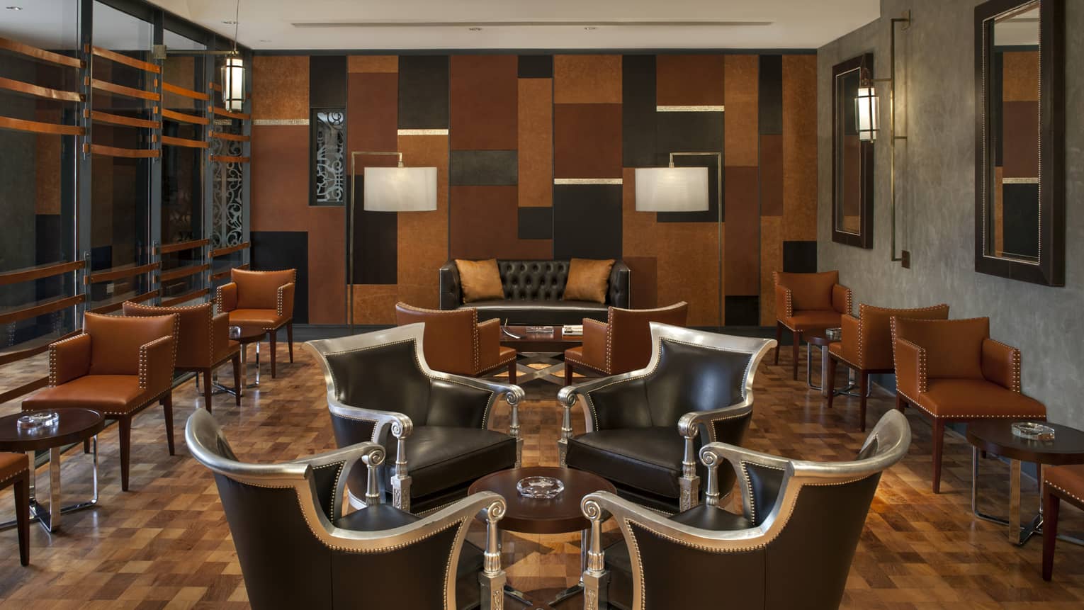 Intimate meeting room with four ornate arm chairs facing each other, with wooden floors and mosaic wall