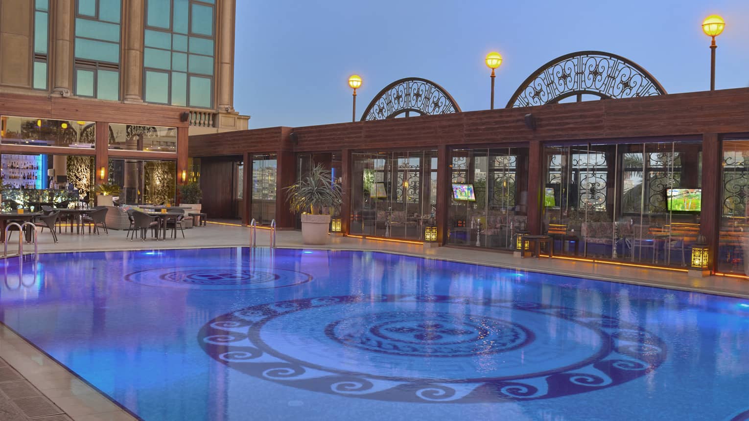 Outdoor pool illuminated under moonlit sky