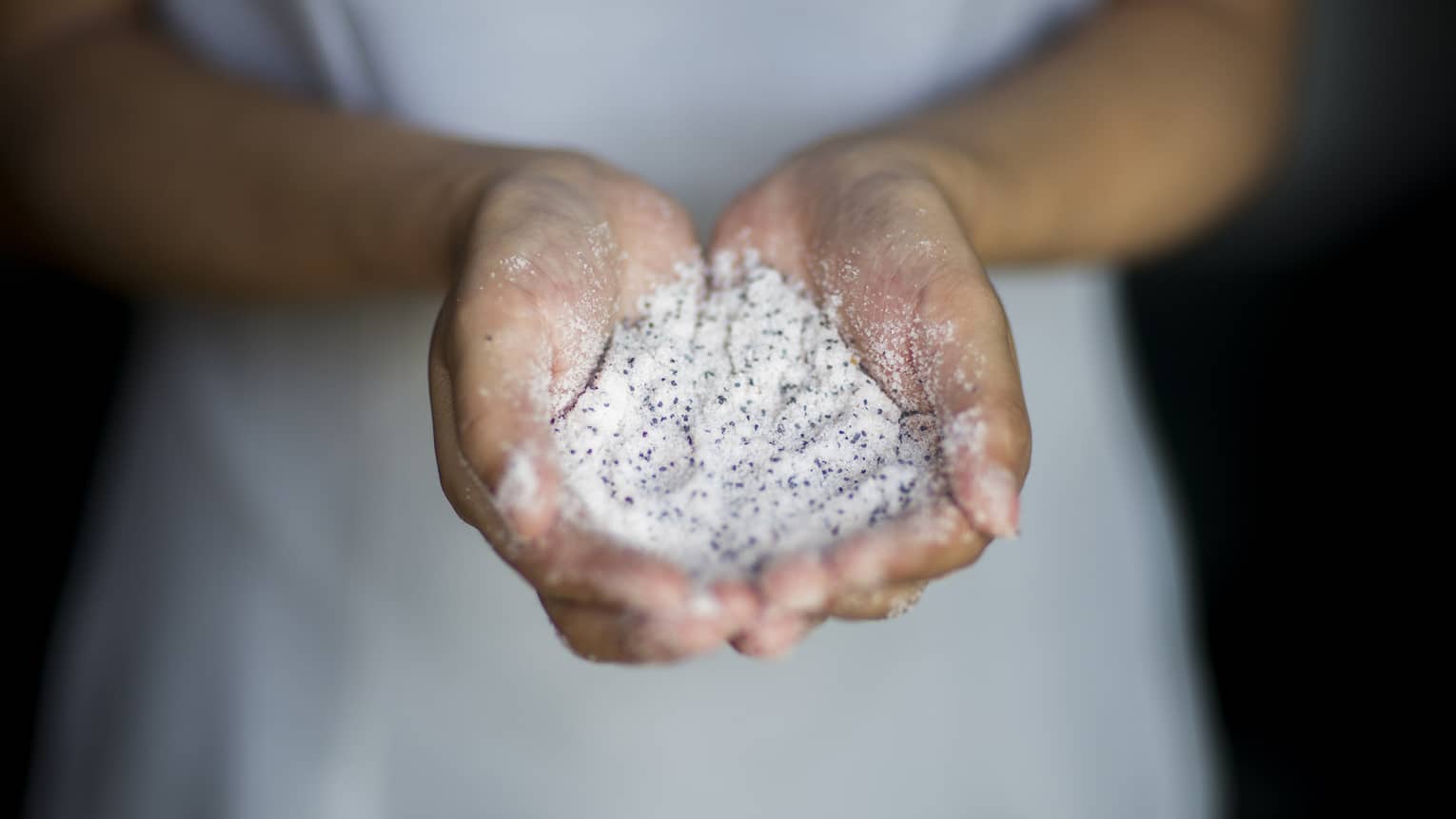 A woman holding sand in her hands.