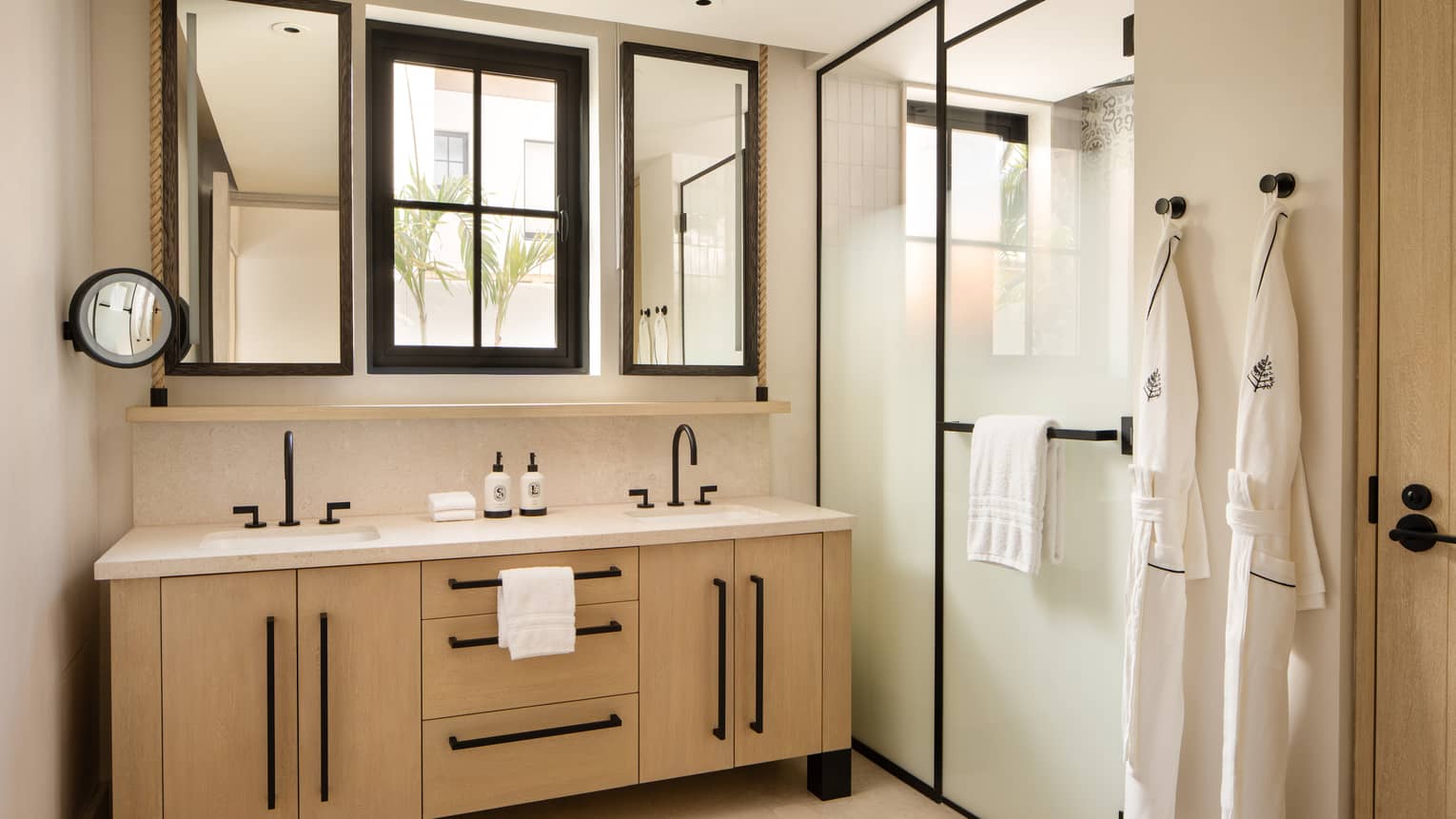 Luxury villa bathroom with window over a double vanity and a walk-in shower with frosted glass