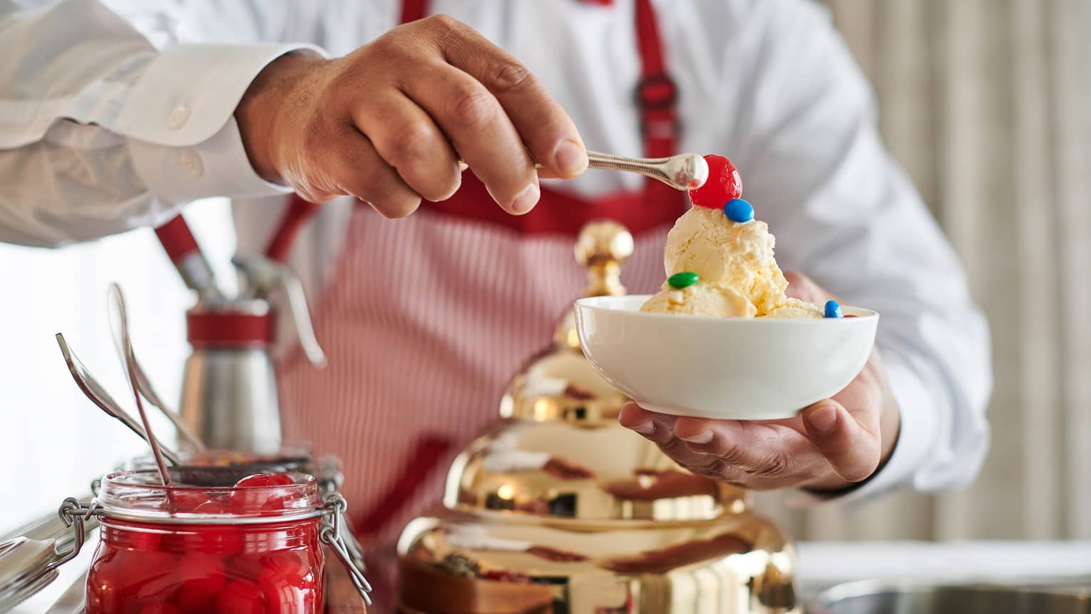 Man making an ice cream sundae from a retro Ice Cream Cart