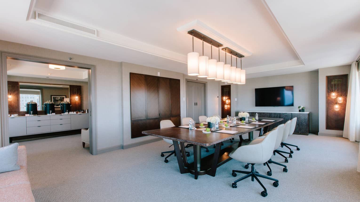 A meetings area with a large wood table and well lit areas.