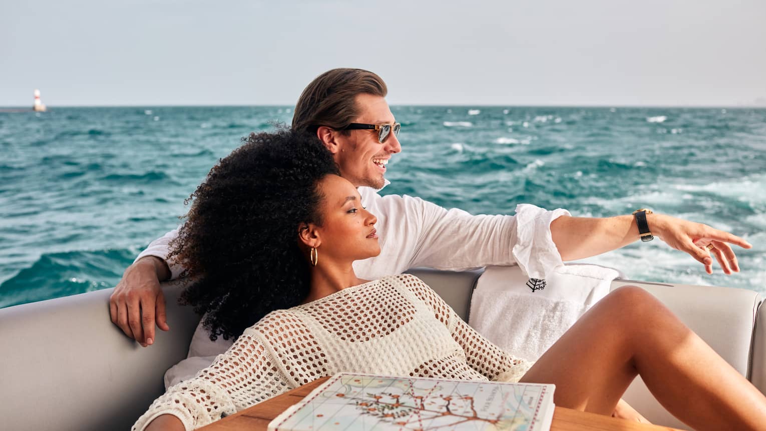 A man and woman relaxing on a boat on water.