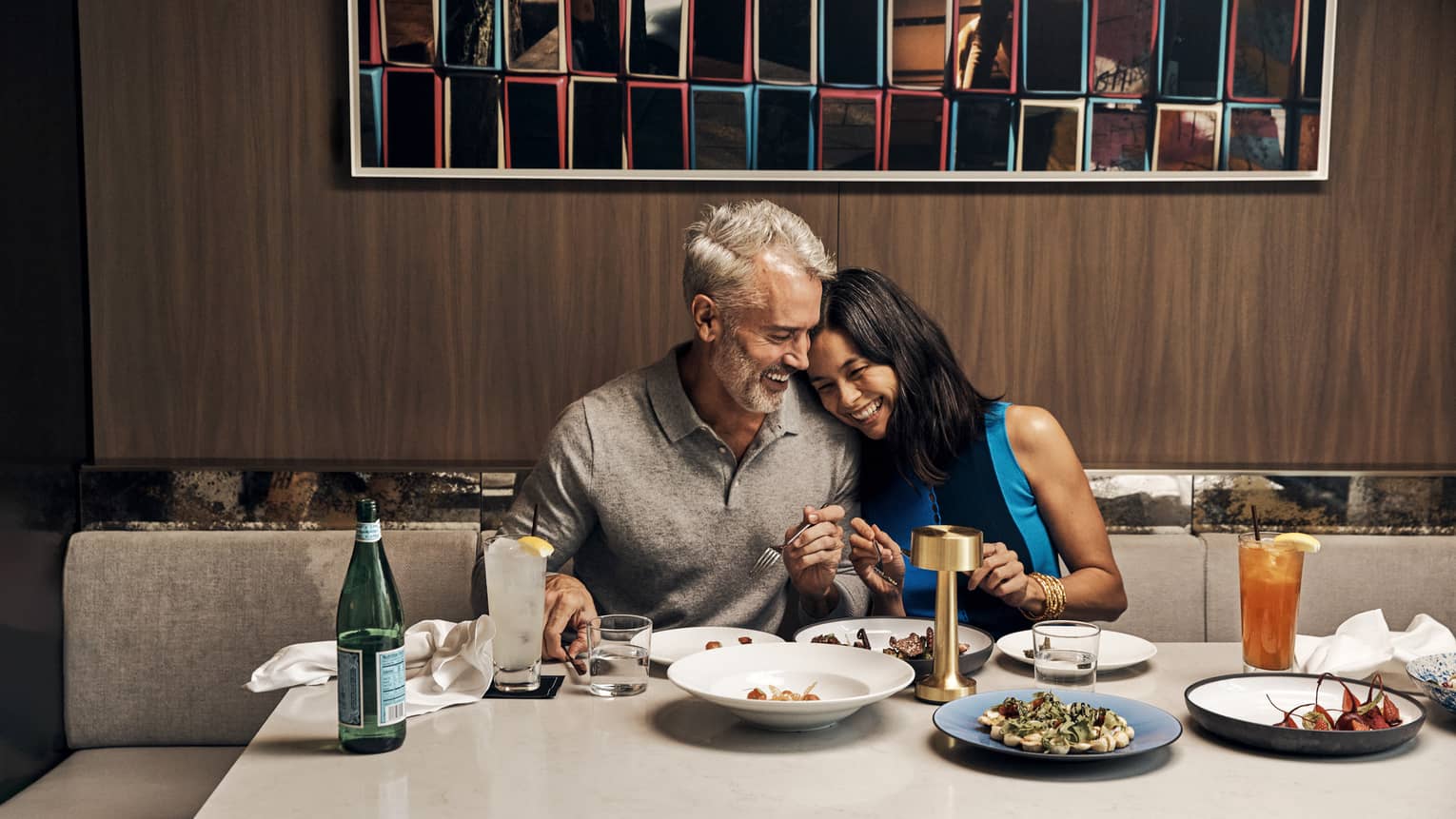 A man and woman eating food at a large table.