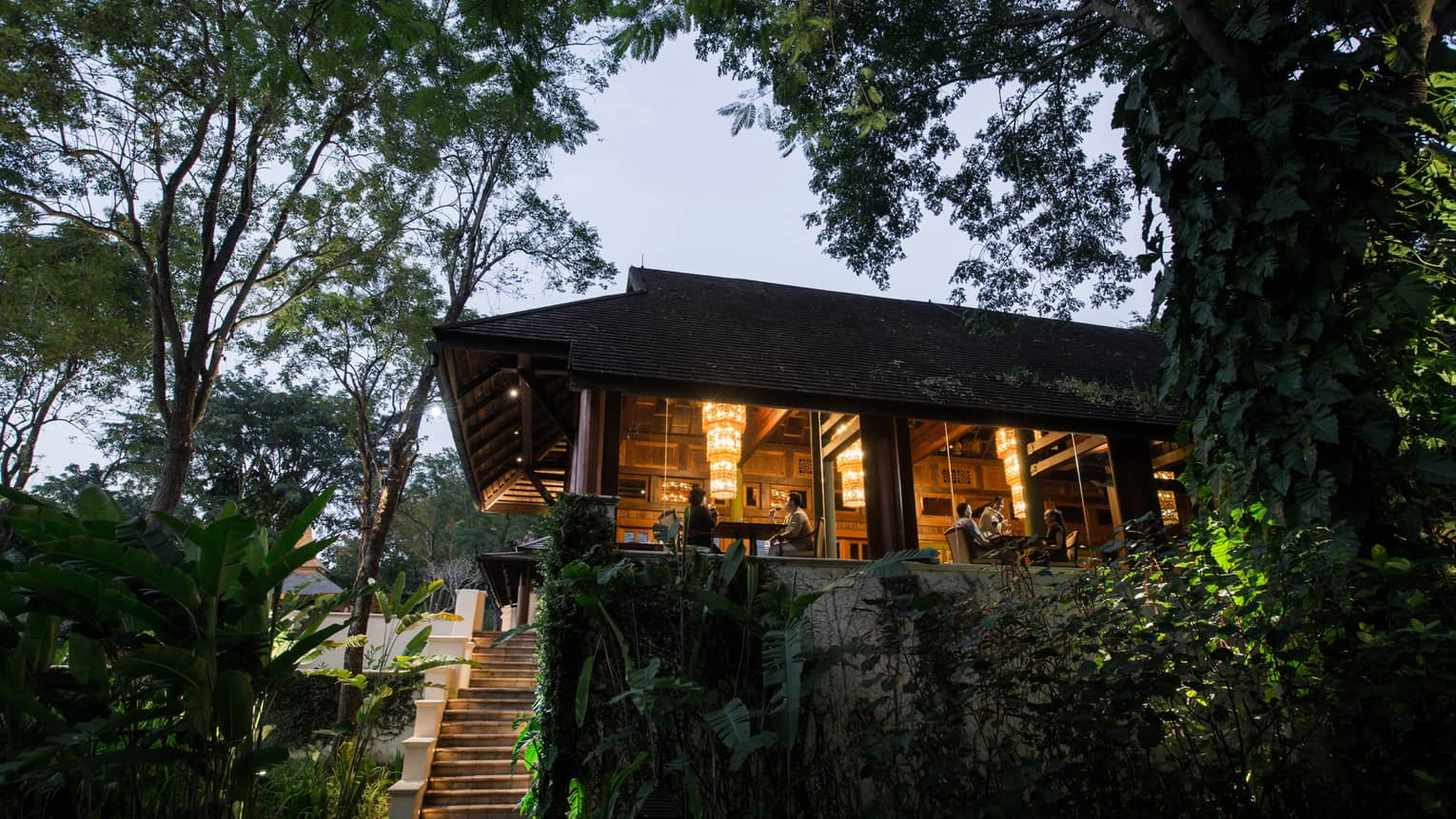 Wood steps leading up to KHAO restaurant at dusk, diners visible in window