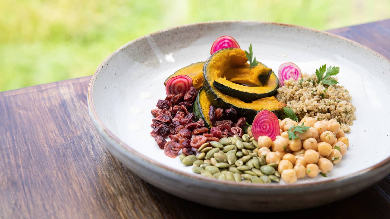 A bowl filled with a variety of grains and sliced mango. 