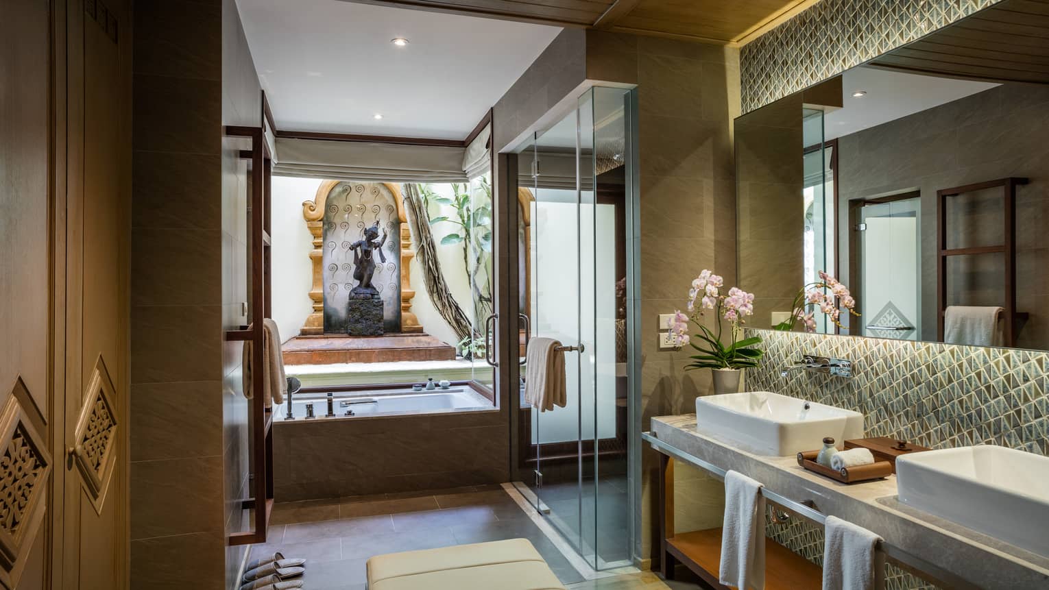 Garden Pavilion Room bathroom with double sink vanity, glass shower, tub under statue, monument