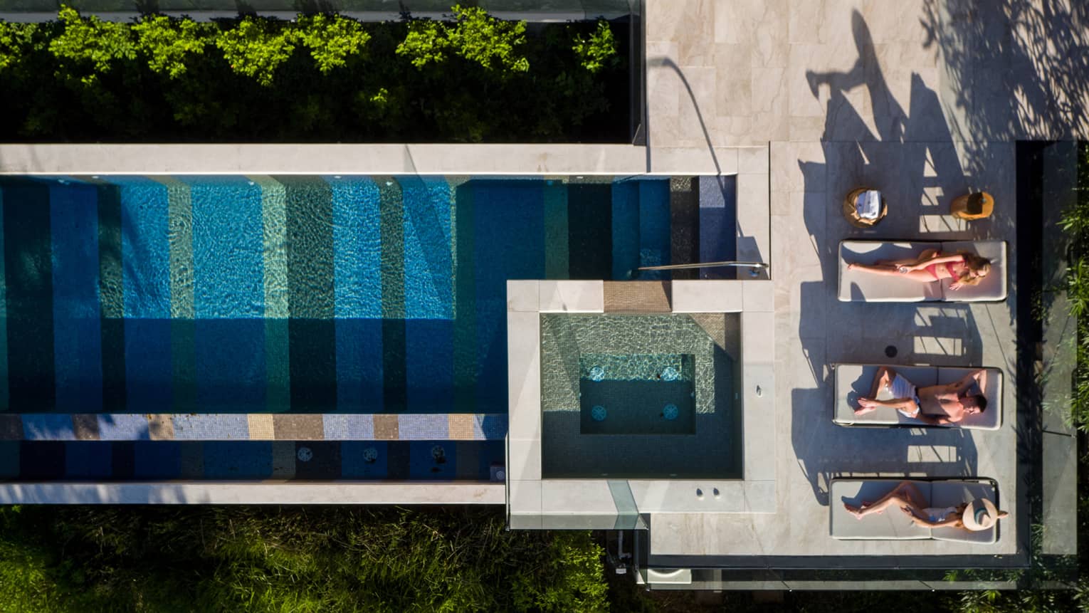 Aerial view of pool and four people lounging