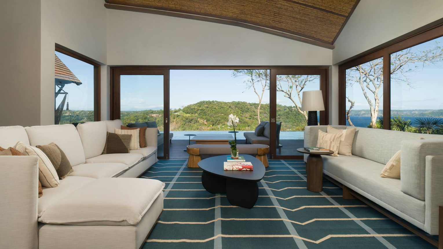Living room with two large cream sofas, walls of windows