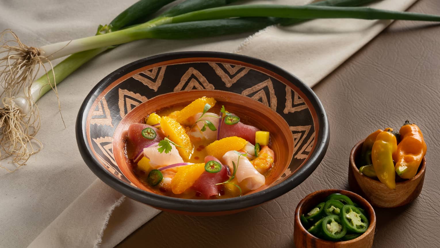 Seafood Ceviche served in a red clay bowl with decorative black markings
