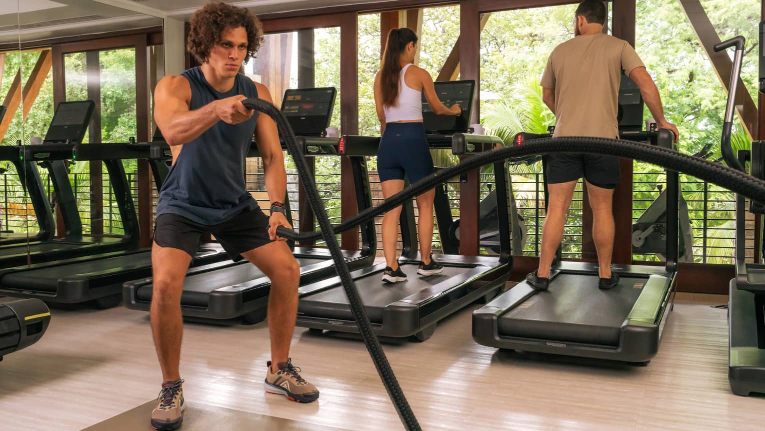 Three people exercise in a resort gym
