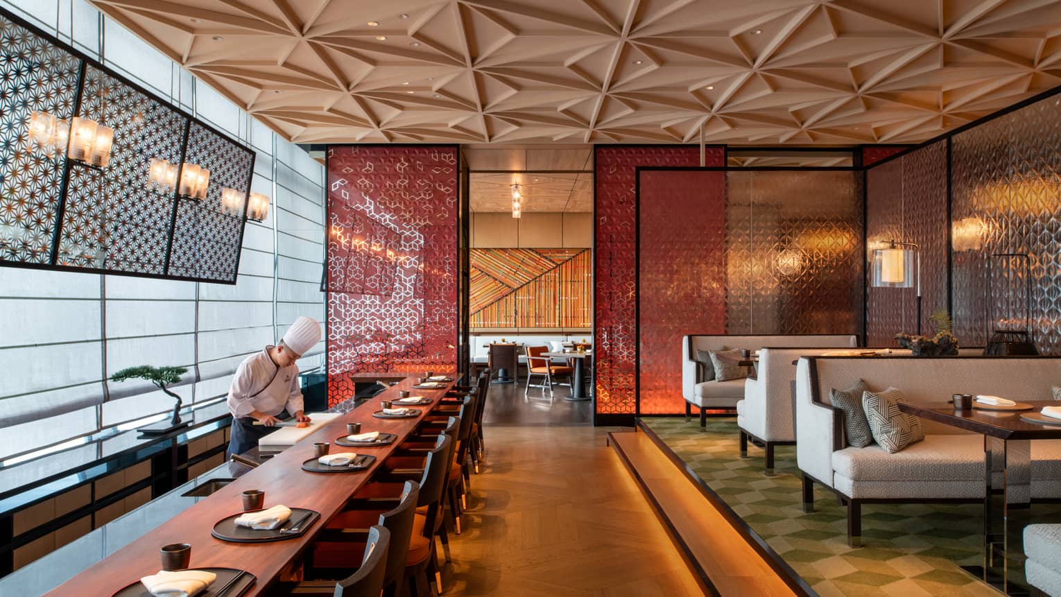 Chef prepares food at long dining bar at Yotsuba Japanese restaurant
