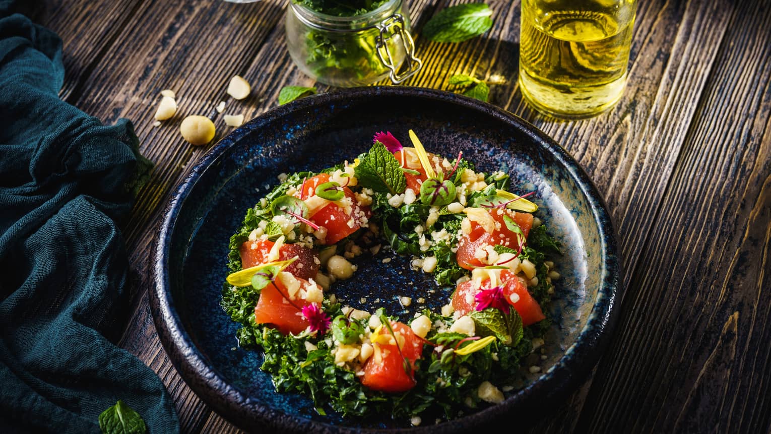 A black dish with greens and watermelon arranged in a circle.