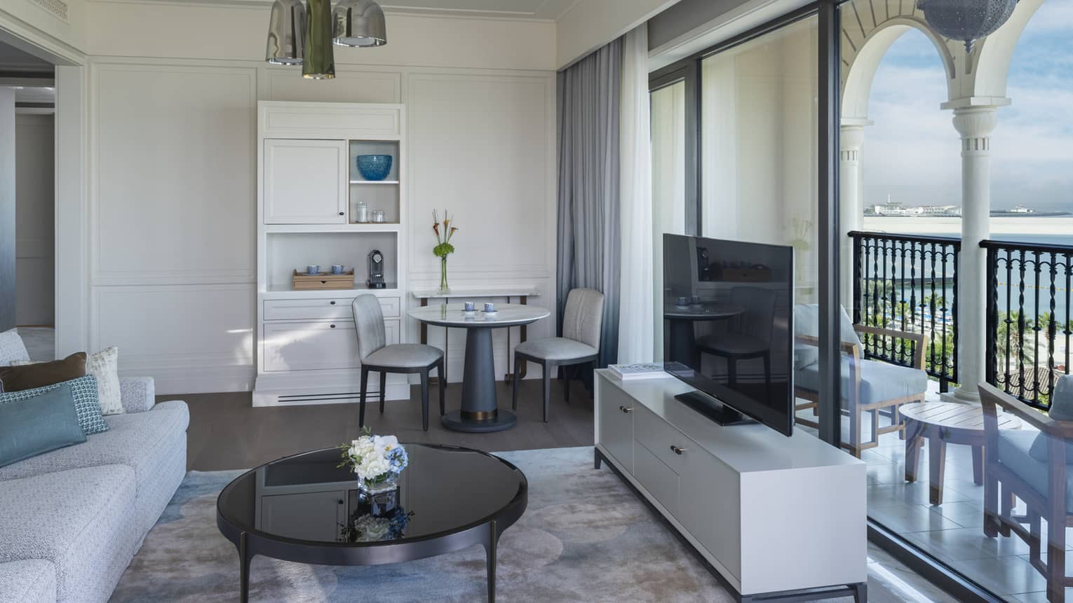 Hotel suite living room with wall of sliding glass windows opening to a sea-view terrace