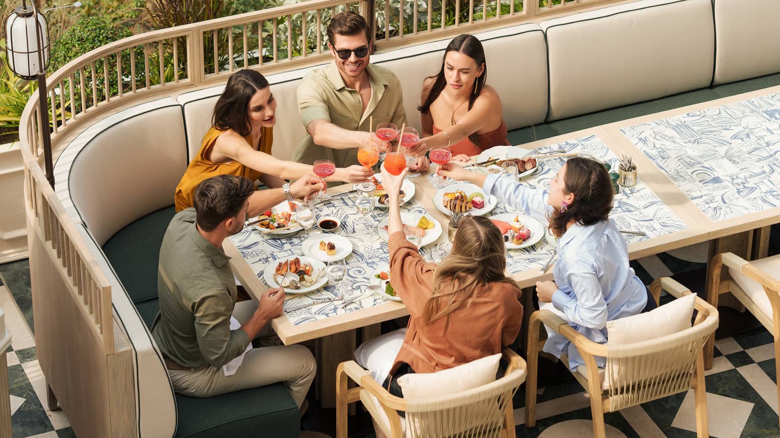 Group of six people dining together at an outdoor restaurant table