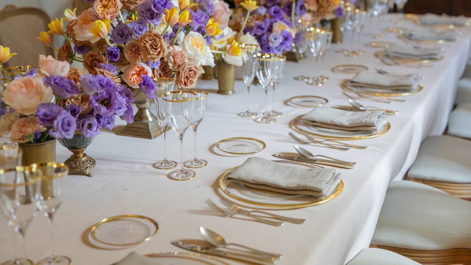 Elegantly set formal banquet table with colourful flower centrepieces